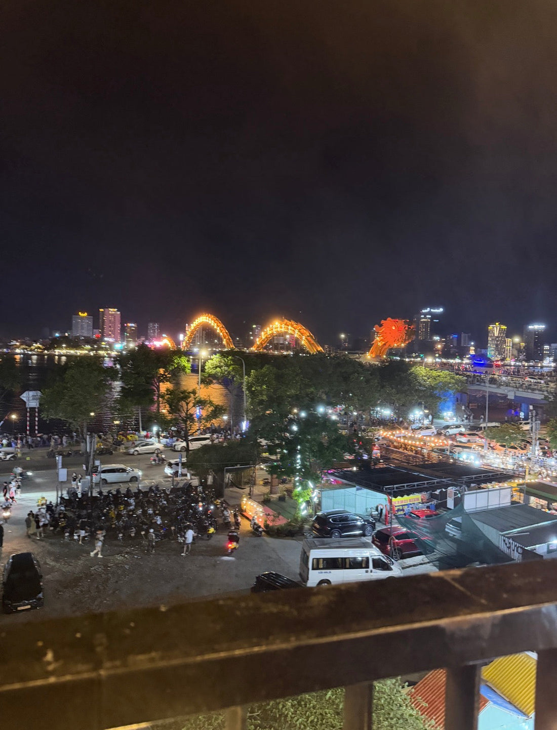 Dragon Bridge Da Nang lit up at night, seen from Dragon Ball Rooftop above the Sơn Trà night market